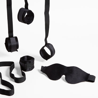 Black bondage cuffs and blindfold on a white background