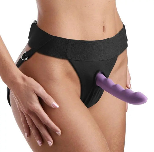 Black thong with a purple strap-on dildo on a white background