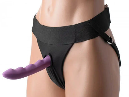Black thong with purple strap-on dildo stimulator on a white background