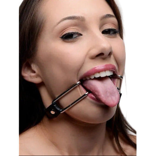 Close-up of a woman with a metal tongue gag in her mouth.