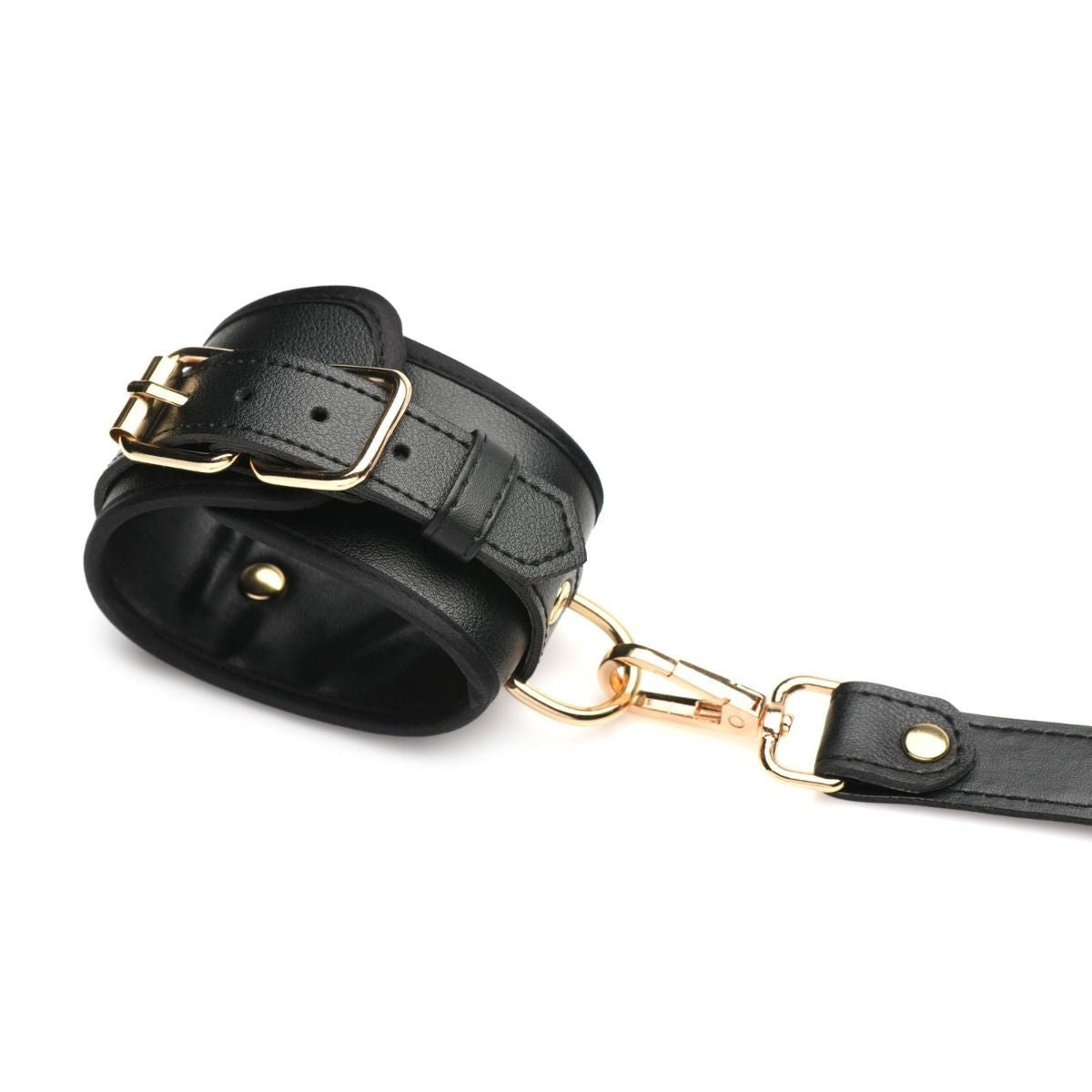 Black leather restraint with gold hardware on a white background