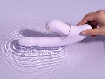 White electronic device being submerged in water with a hand holding it, on a light purple background.
