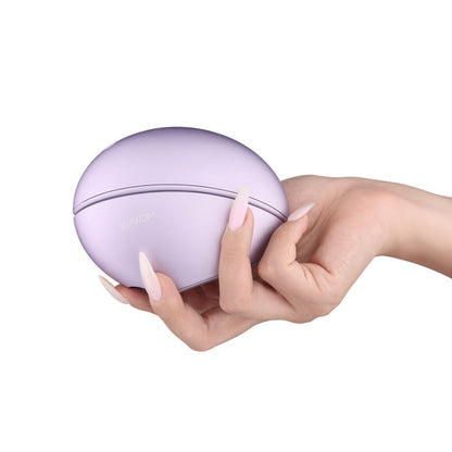 Hand holding a purple spherical device against a white background