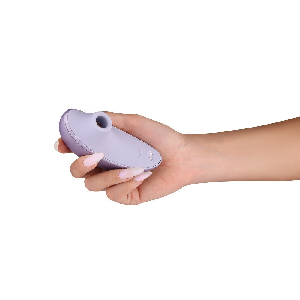 Hand holding a purple electronic device against a white background