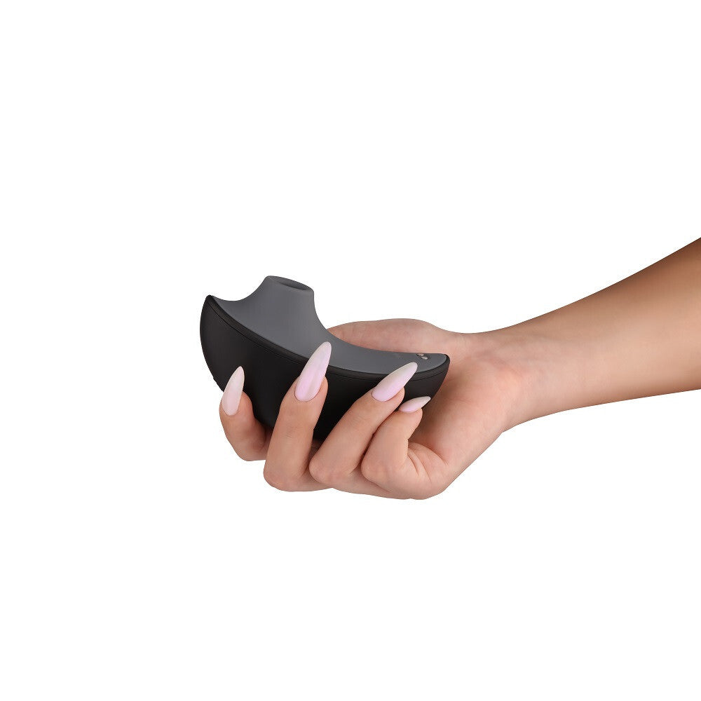 Hand holding a black, curved object against a white background