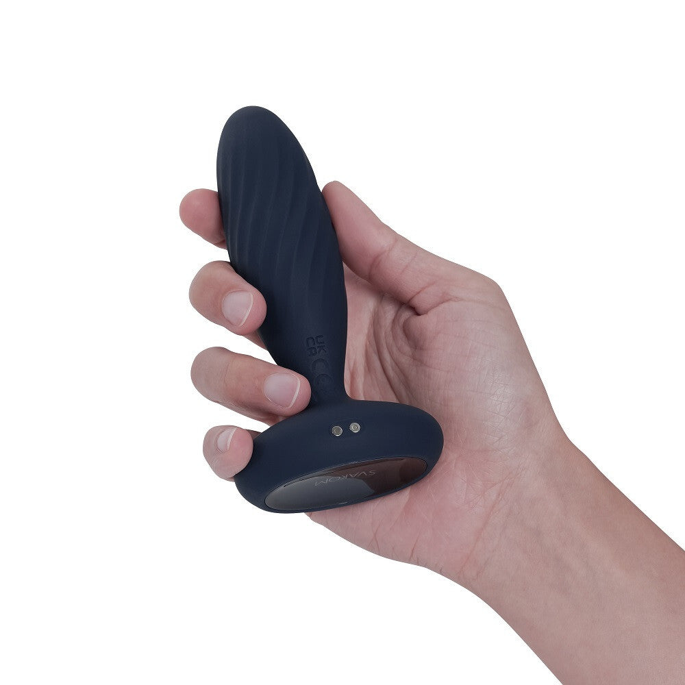 Hand holding a dark blue silicone product on a white background