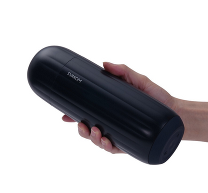 Black cylindrical masturbtor held in a hand with a white background