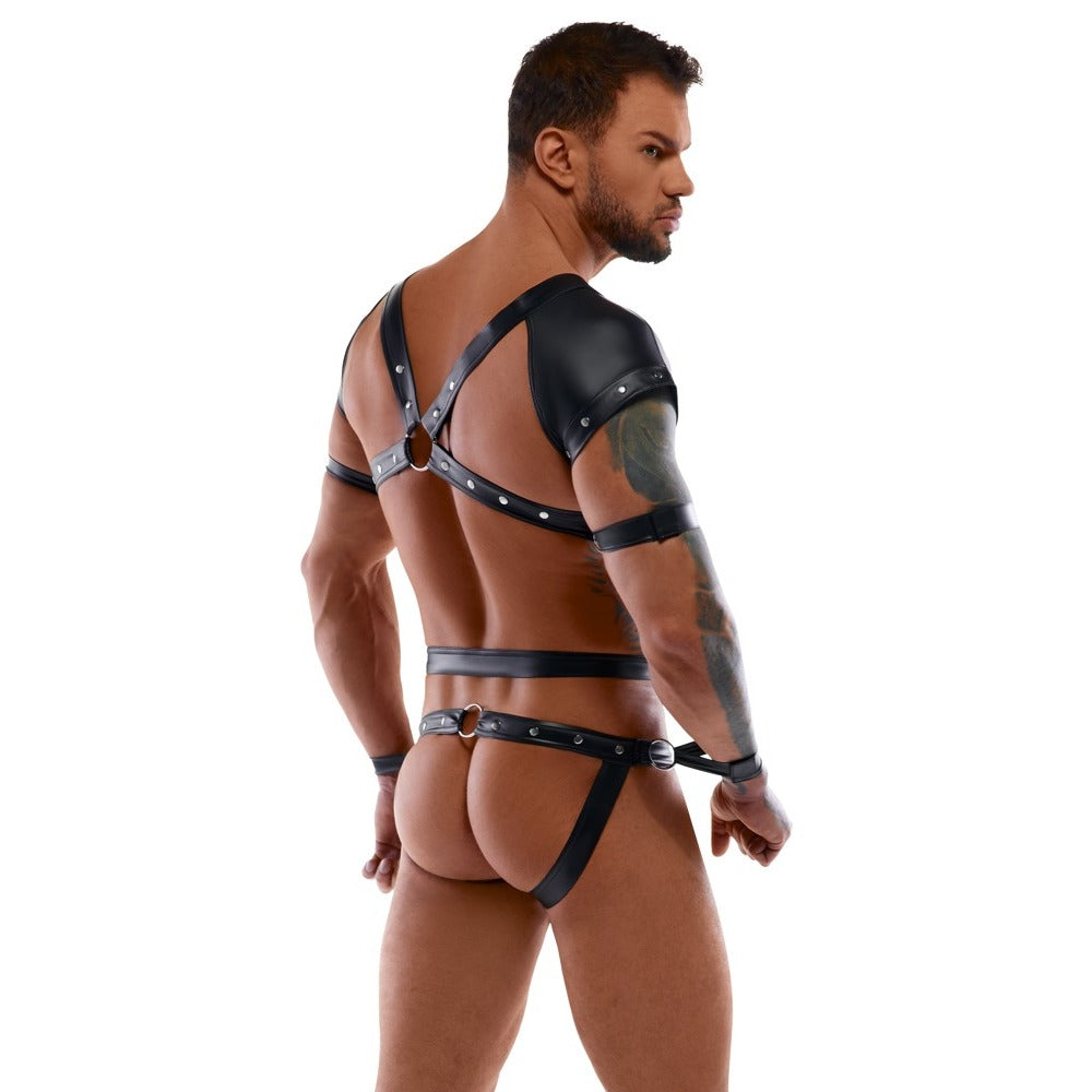 Man wearing a black leather harness on a white background