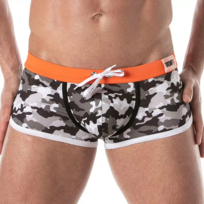 Camouflage swim shorts with orange waistband on a white background