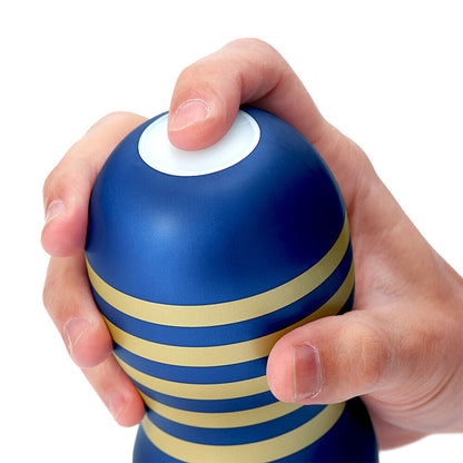 Hand holding a blue and yellow striped stroker against a white background