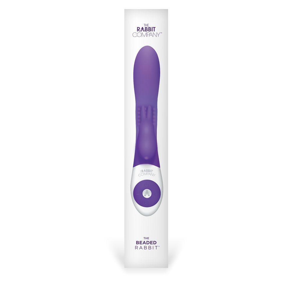 Purple and white electronic massage device in packaging on a white background