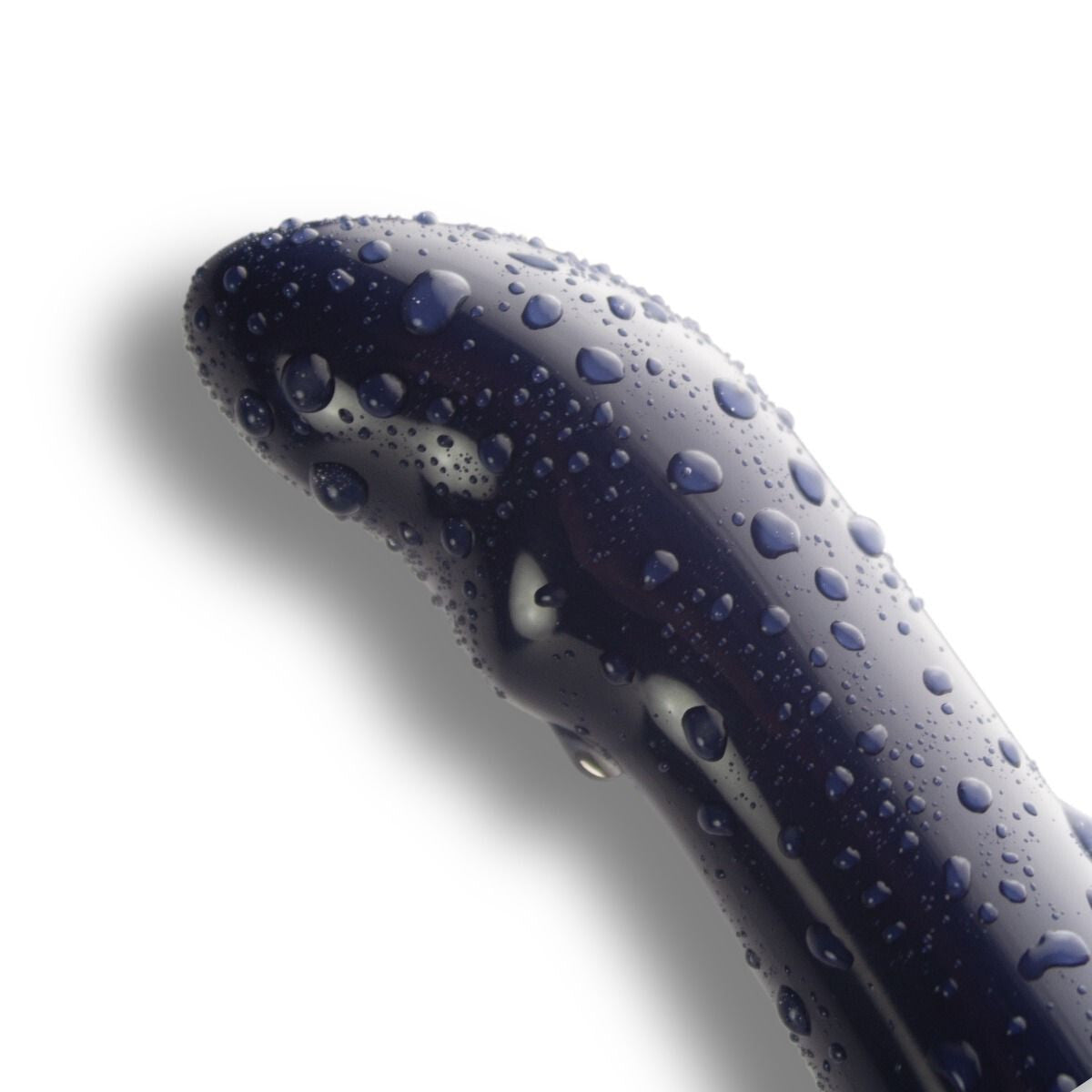 Close-up of a dark blue object with water droplets on a white background