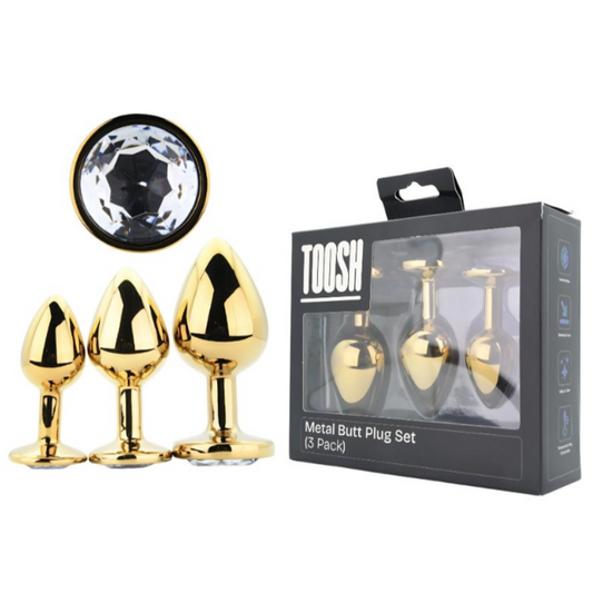 Gold metal butt plug set with packaging labeled 'TOOSH' on a white background.