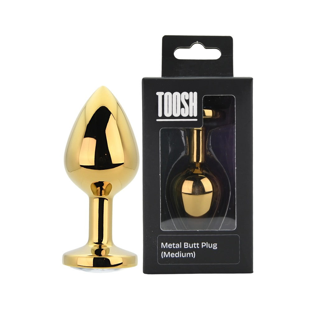 Gold metal butt plug with packaging labeled 'TOOSH' on a white background