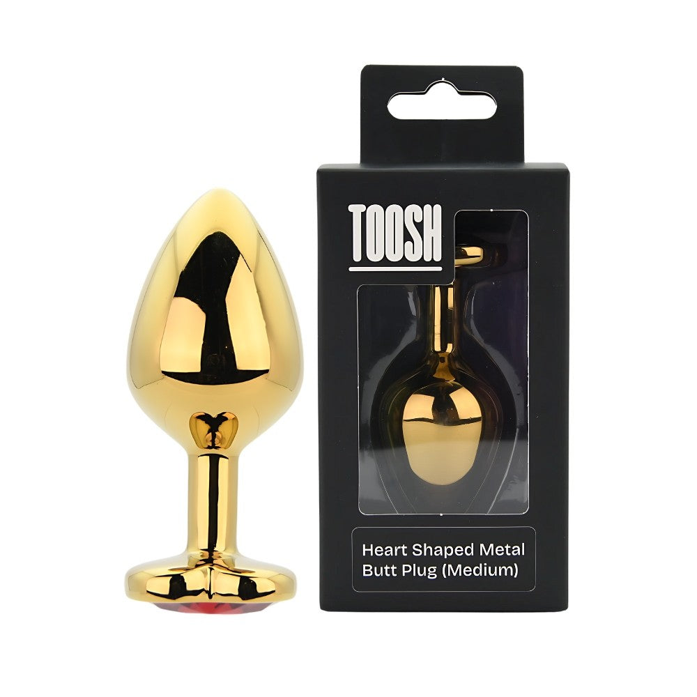 Gold heart-shaped metal butt plug with packaging labeled 'TOOSH' on a white background