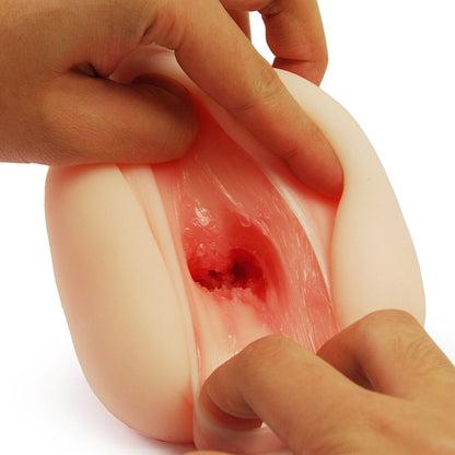 Close-up of a hand holding a realistic silicone model of a human vagina