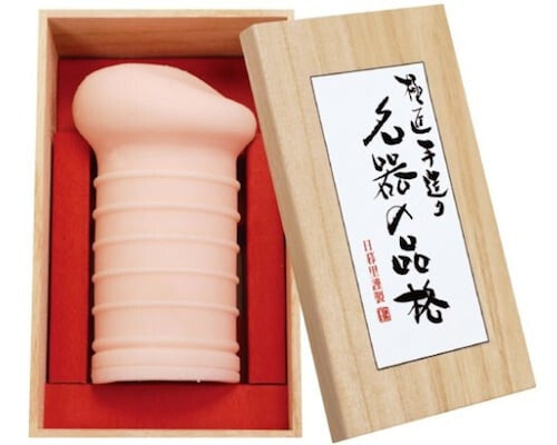 Wooden box with a cylindrical pink object inside, featuring Japanese text on the lid.