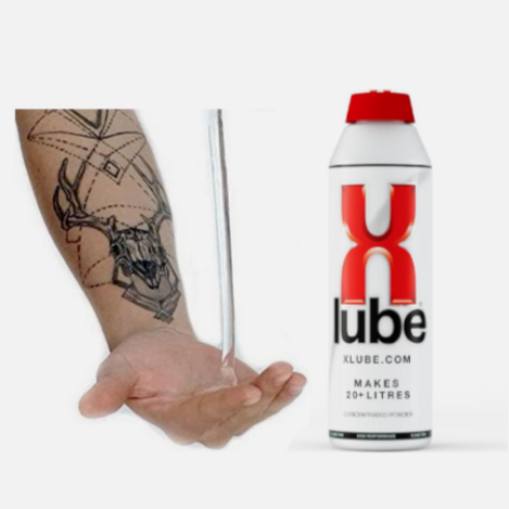 X-Lube can held in a hand with a tattoo on a white background