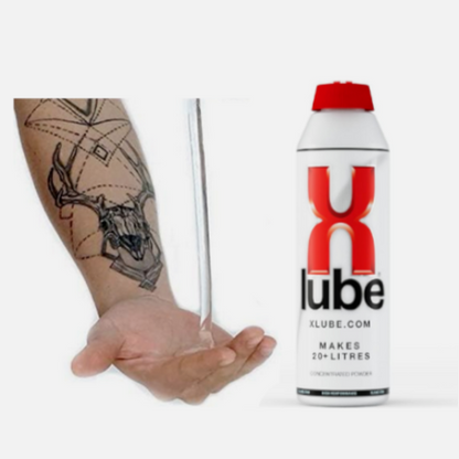 X-Lube can held in a hand with a tattoo on a white background