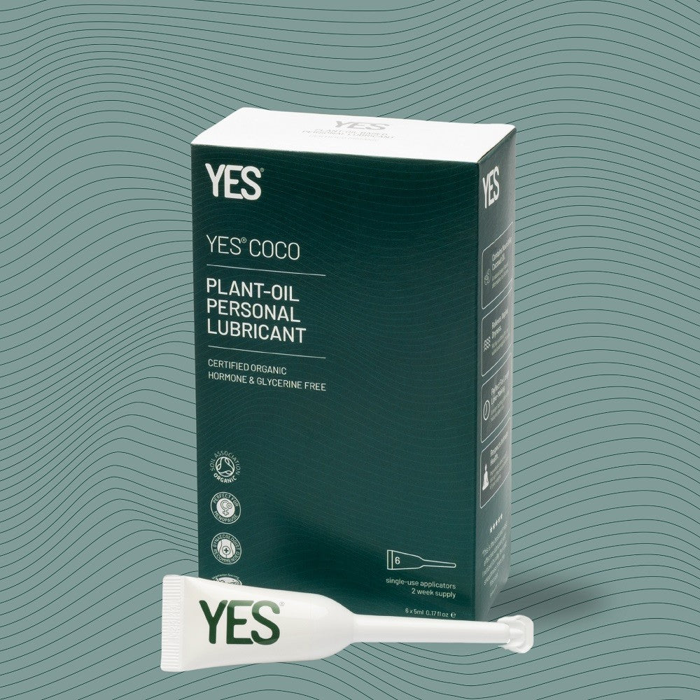 YES COCO plant-oil personal lubricant packaging with a sample on a green wavy background