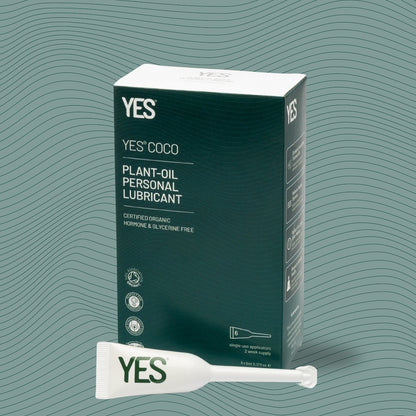 YES COCO plant-oil personal lubricant packaging with a sample on a green wavy background