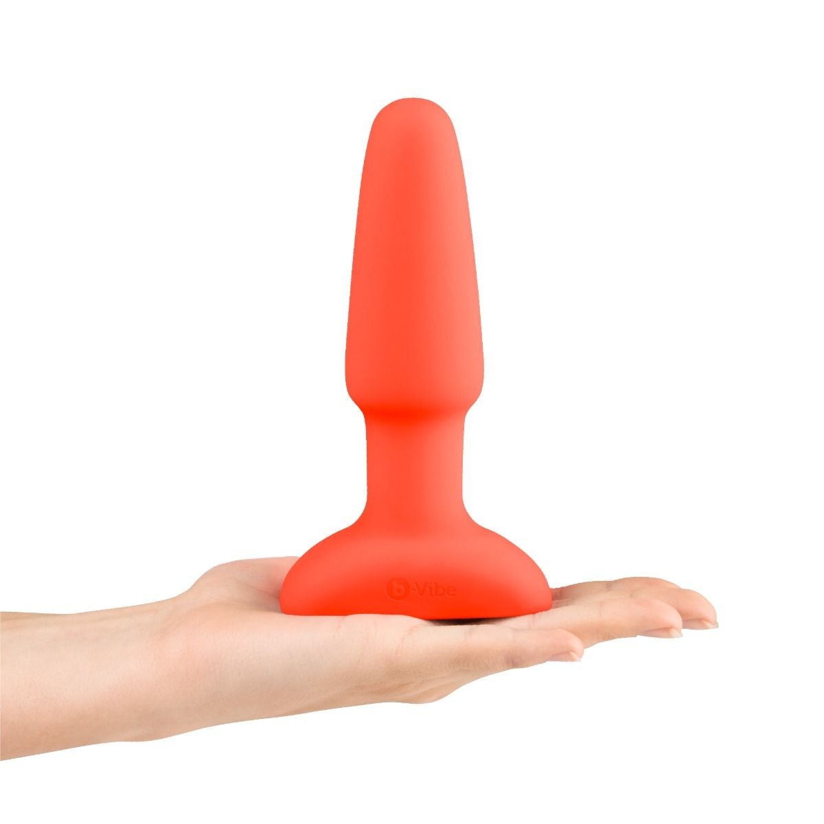 Orange silicone butt plug held in a hand on a white background