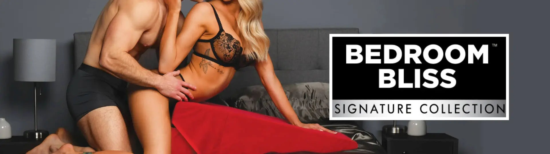 Two people in bed with a 'Bedroom Bliss' sign in the background