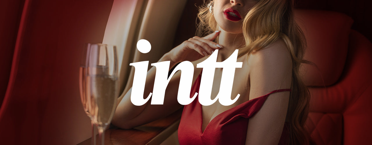 Woman in a red dress with a glass of champagne, featuring the 'intt' logo.
